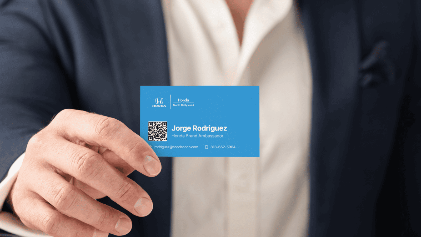 A closeup of a salesperson holding up a business card